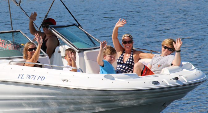 Two moms and three boys sitting on the front of a boat in Destin, Florida
