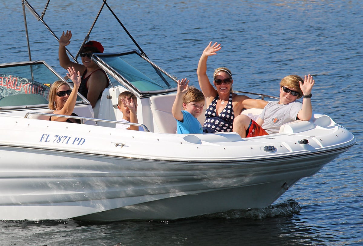 kids and mom on the bow of a boat floating through the ocean in destin, florida