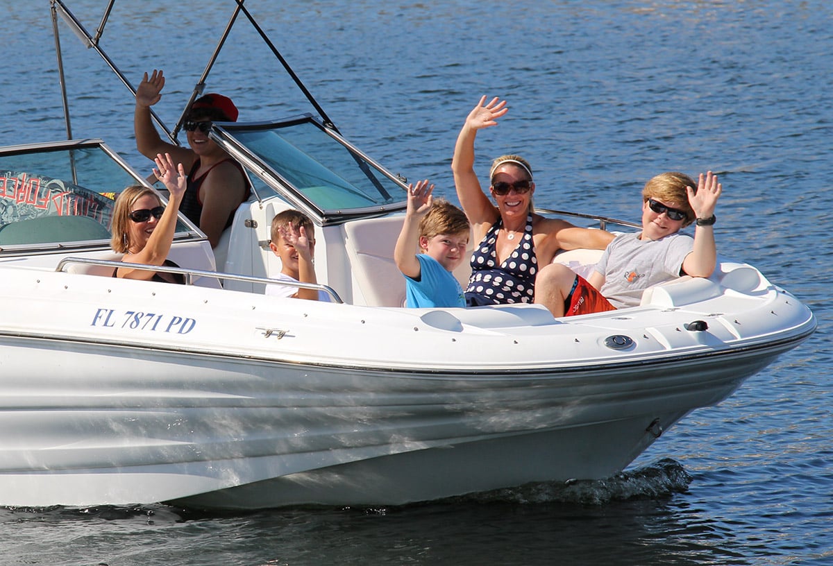 kids and mom on the bow of a boat floating through the ocean in destin, florida