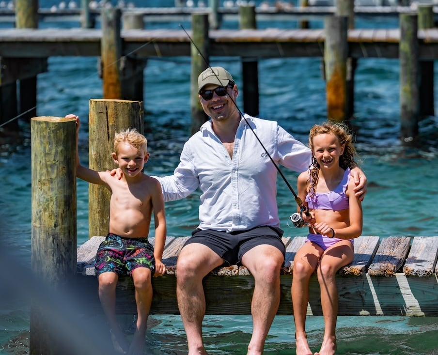dad daughter and son fishing and smiling on the dock in destin fl