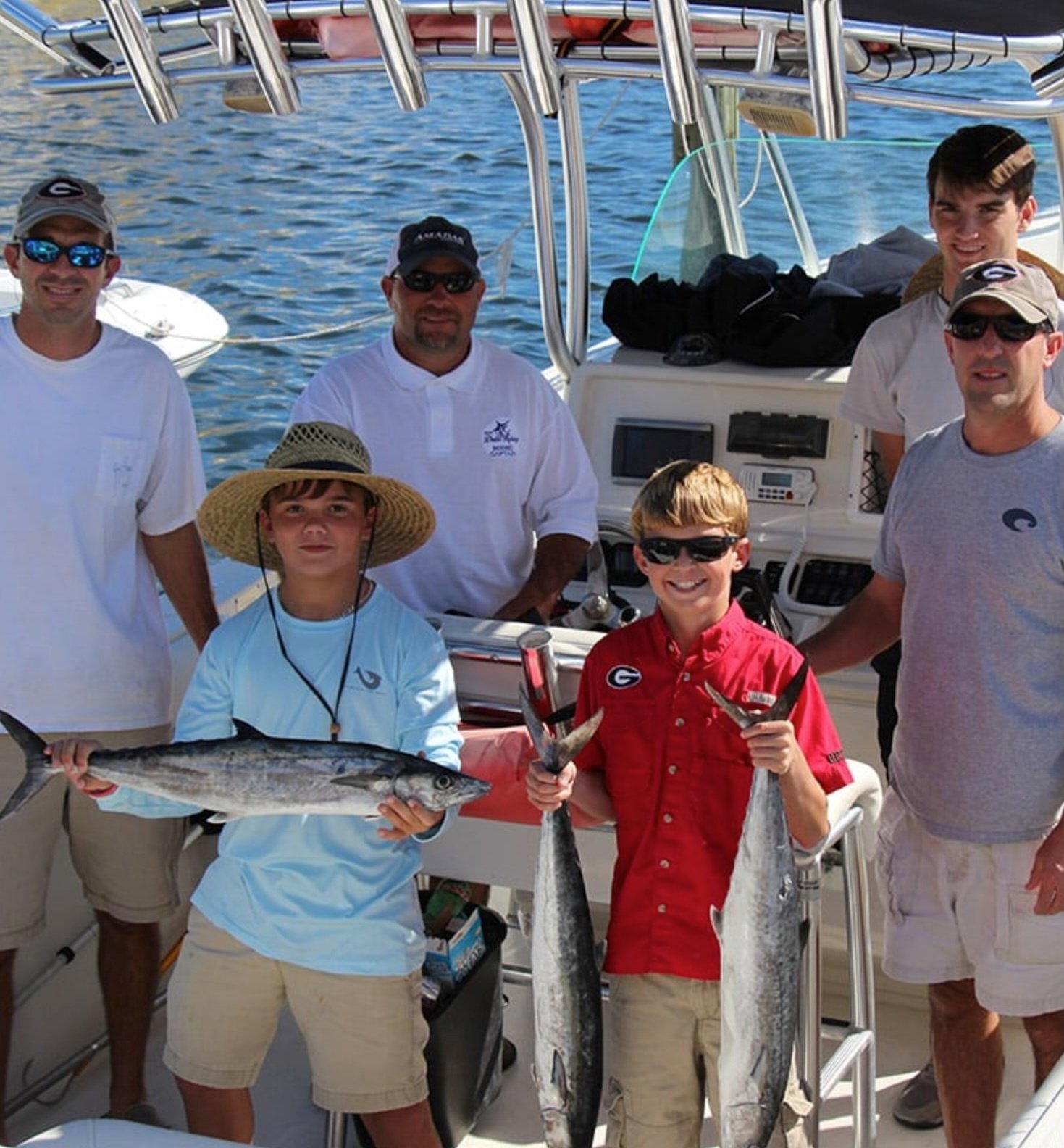 family with fish on board of center console boat