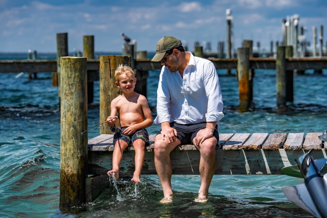 father and son fishing on a dock in the Destin Harbor
