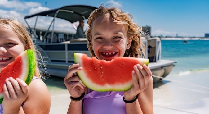 little girls eating watermelon at east pass beach destin