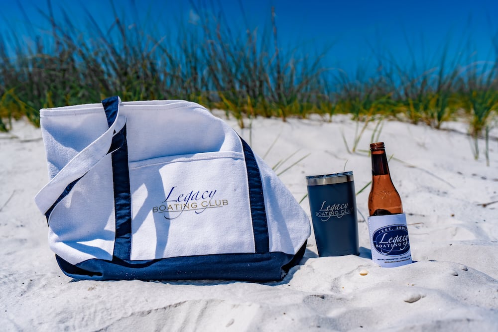 legacy boating club bag, thermos, and can koozie on the beach near 30A florida