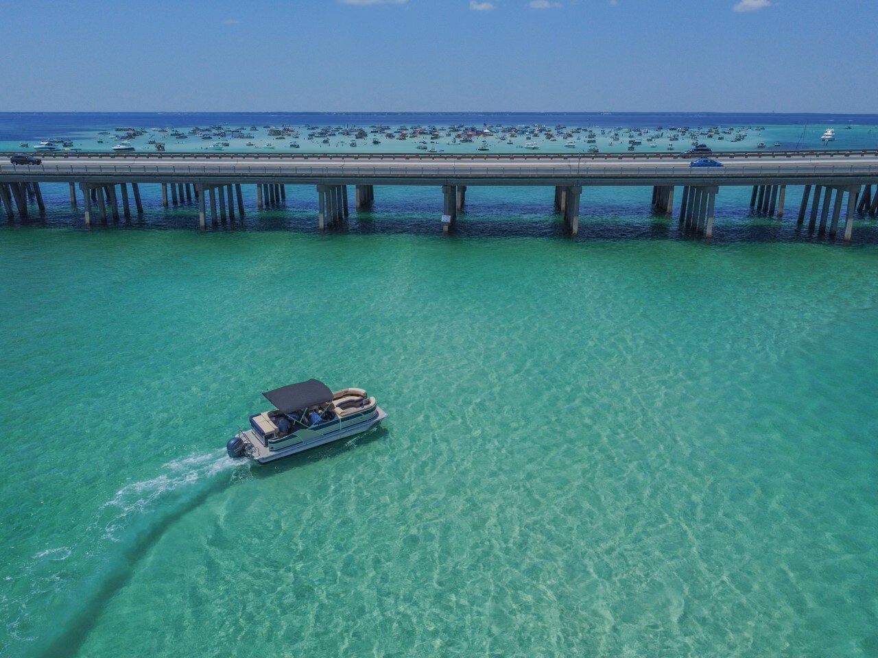 pontoon boat driving through the water off the coast of destin florida