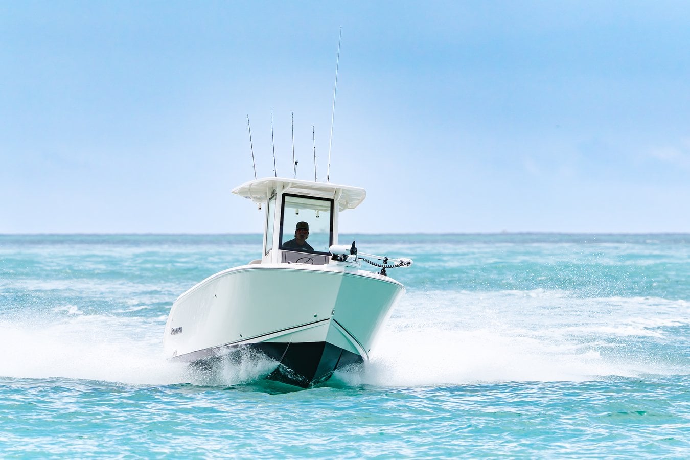 Sailfish 232 center console fishing boat racing through the waves toward the camera on open water
