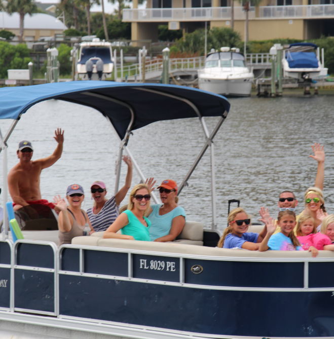 family waving on a tritoon boat in Destin, Florida 