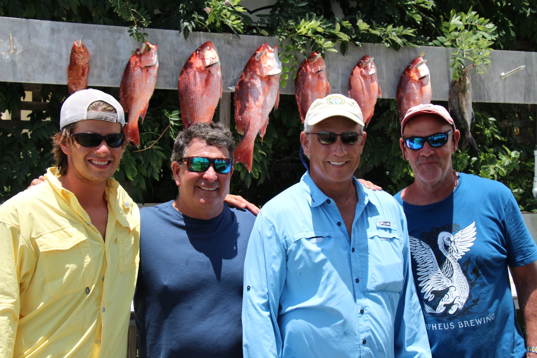 Four men standing in front of fish at Legacy Boating Club