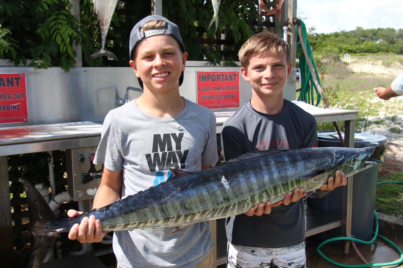 Two kids holding a large fish at Legacy Boating Club in Destin, Florida