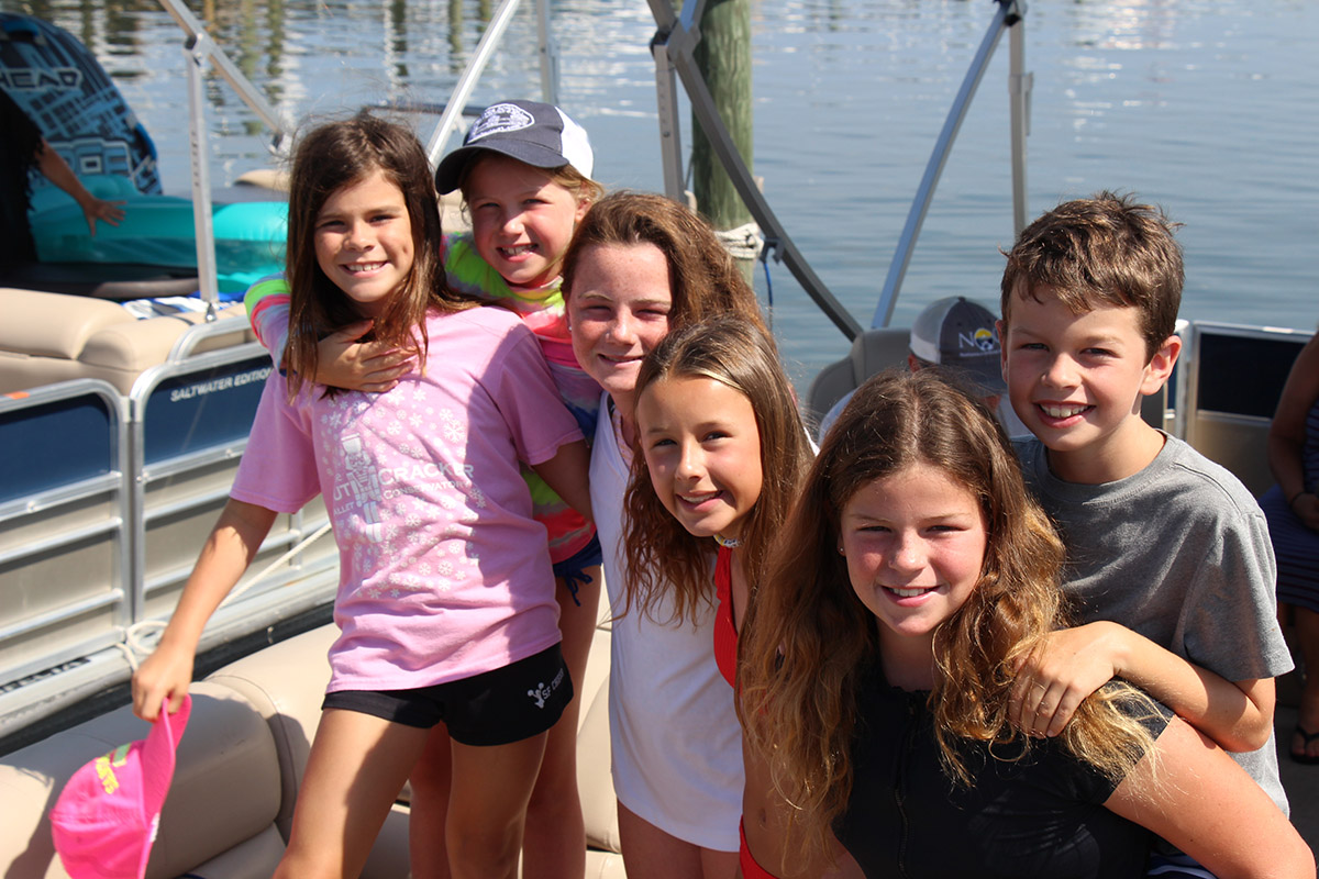 Group of kids smiling in front of a boat in Destin, Florida