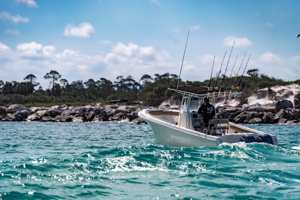 center console sailfish boat floating near shell island rocks