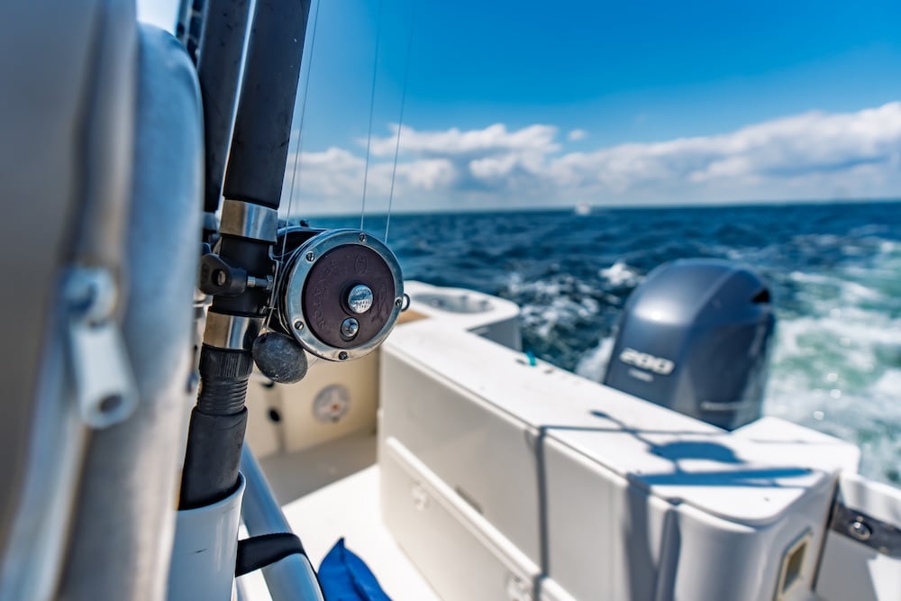 close up of fishing reel on the back of a single engine center console boat