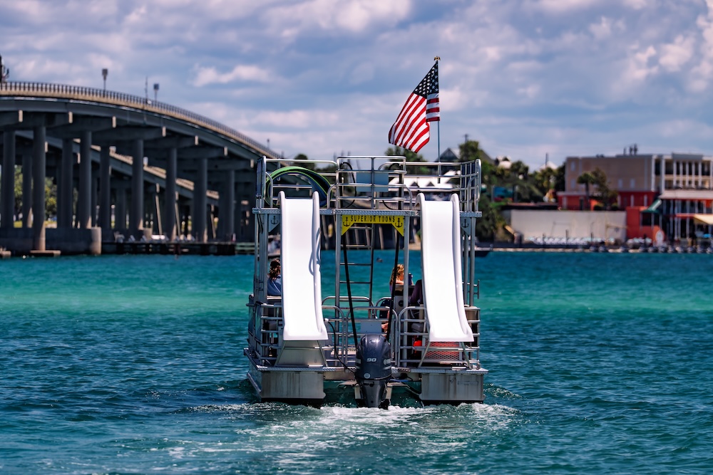 double decker pontoon boat cruising near the destin harbor bridge