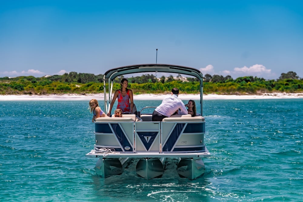 family leaving destin beach on tritoon boat