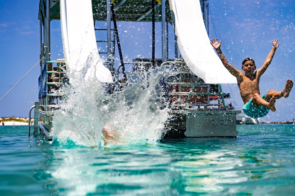 kids sliding and splashing into shell island waters from double decker pontoon