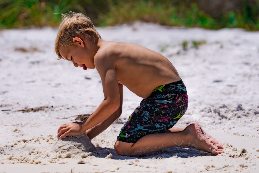 little boy playing in sand at destin fl beach