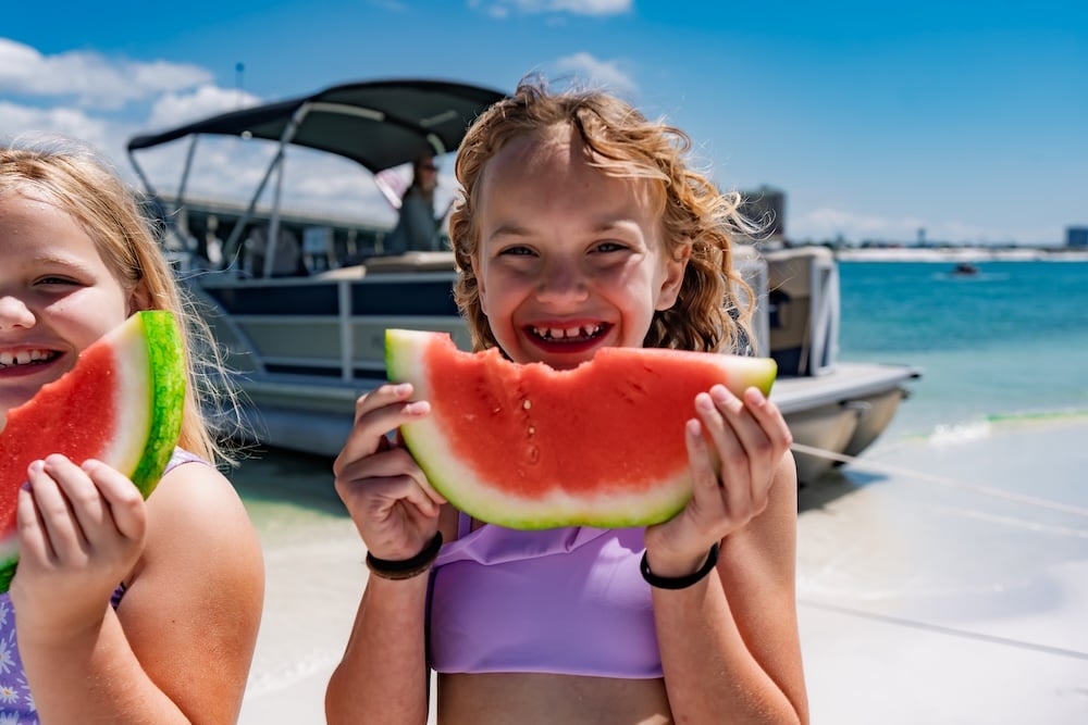little girl enjoying watermelon at west jetty beach in destin fl